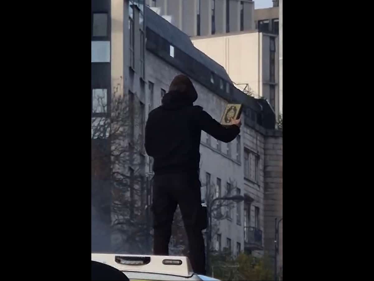 Leeds sees police van set on fire, man climb on top waving Quran